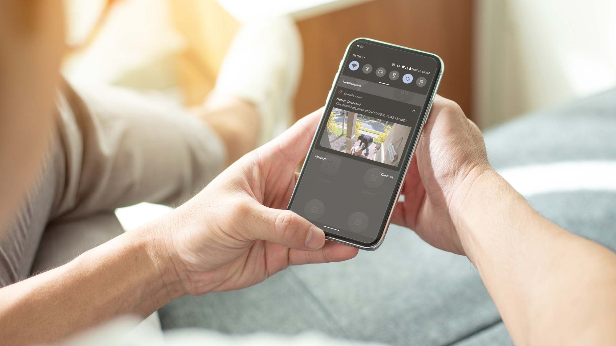 Woman holding phone with control4 interface